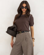 Kontrastowe obszycie swetra podkreślające linię ramion i szyi
