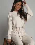 Elegancki kremowy komplet swetrowy z wiązaniem i szerokimi spodniami - stylizacja jesienno-zimowa
